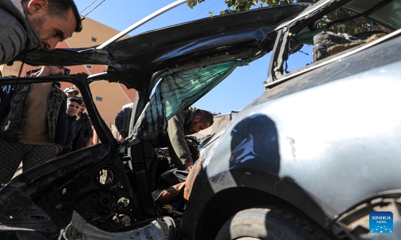 People check the vehicle damaged by an Israeli airstrike in the southern Gaza Strip city of Rafah, on Jan. 7, 2024. Two journalists were killed and another journalist was injured on Sunday in an Israeli airstrike targeting their vehicle in the southern Gaza Strip, according to Hamas media office. (Photo by Rizek Abdeljawad/Xinhua)