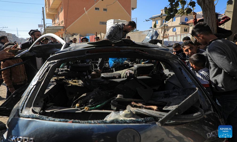 People check the vehicle damaged by an Israeli airstrike in the southern Gaza Strip city of Rafah, on Jan. 7, 2024. Two journalists were killed and another journalist was injured on Sunday in an Israeli airstrike targeting their vehicle in the southern Gaza Strip, according to Hamas media office. (Photo by Rizek Abdeljawad/Xinhua)