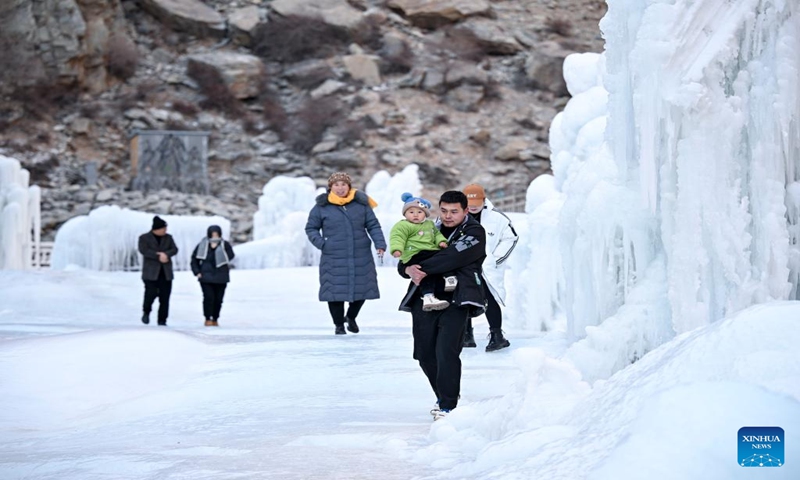 Tourists enjoy the frozen waterfall scenery at the cliff painting scenic area of Helan Mountain in northwest China's Ningxia Hui Autonomous Region, Jan. 5, 2024. (Xinhua/Feng Kaihua)