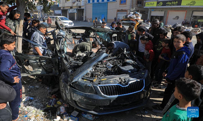 People check the vehicle damaged by an Israeli airstrike in the southern Gaza Strip city of Rafah, on Jan. 7, 2024. Two journalists were killed and another journalist was injured on Sunday in an Israeli airstrike targeting their vehicle in the southern Gaza Strip, according to Hamas media office. (Photo by Yasser Qudih/Xinhua)