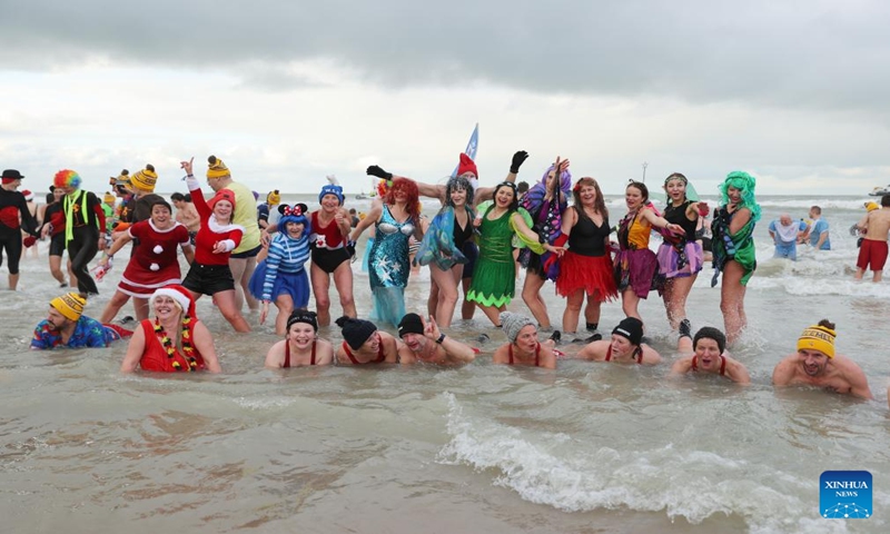 People pose for photos during the traditional New Year's Dive in Ostend, Belgium, Jan. 6, 2024. Thousands of people braved the cold North Sea on Saturday to welcome the New Year. (Xinhua/Zhao Dingzhe)