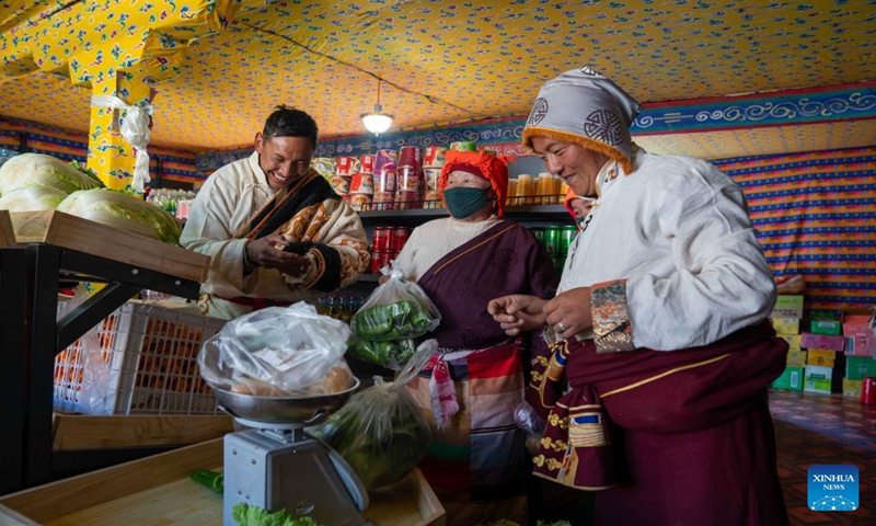 Sherab Gyatso (1st R), a store manager, weighs vegetables for a villager at a direct sales store in the remote Beiga No.4 Village in Xainza County, southwest China's Xizang Autonomous Region, Jan. 5, 2024. The Xainza County in Nagqu City, southwest China's Xizang Autonomous Region, situated at an average elevation of 4,700 meters. Traditionally, local herders' diet relies on meat and tea, lacking fruits and vegetables.(Xinhua/Tenzing Nima Qadhup)