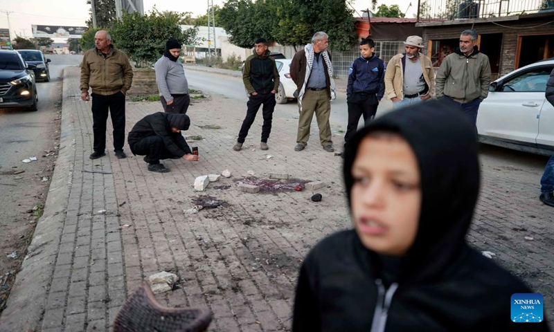 People check the site of a strike in the West Bank city of Jenin, Jan. 7, 2024. Seven Palestinians were killed on Sunday morning by an Israeli drone strike in the occupied West Bank, while an Israeli police officer was killed when her vehicle hit a roadside bomb, Israeli and Palestinian sources said on Sunday.(Photo by Ayman Nobani/Xinhua)