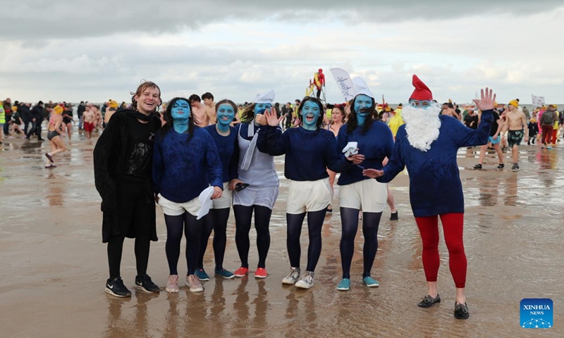 People pose for photos during the traditional New Year's Dive in Ostend, Belgium, Jan. 6, 2024. Thousands of people braved the cold North Sea on Saturday to welcome the New Year. (Xinhua/Zhao Dingzhe)