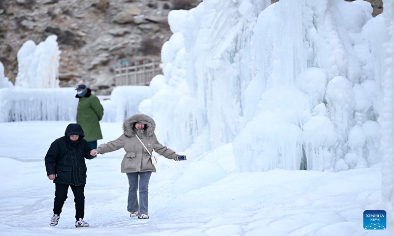 Tourists enjoy the frozen waterfall scenery at the cliff painting scenic area of Helan Mountain in northwest China's Ningxia Hui Autonomous Region, Jan. 5, 2024. (Xinhua/Feng Kaihua)