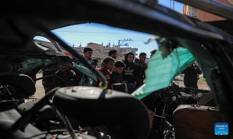 People check the vehicle damaged by an Israeli airstrike in the southern Gaza Strip city of Rafah, on Jan. 7, 2024. Two journalists were killed and another journalist was injured on Sunday in an Israeli airstrike targeting their vehicle in the southern Gaza Strip, according to Hamas media office. (Photo by Yasser Qudih/Xinhua)