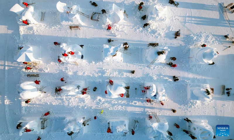 This aerial photo taken on Jan. 7, 2024 shows contestants working on snow sculptures at the Sun Island scenic area in Harbin, northeast China's Heilongjiang Province. An international snow sculpture competition is held here, attracting snow sculptors from 12 countries. (Xinhua/Zhang Tao)