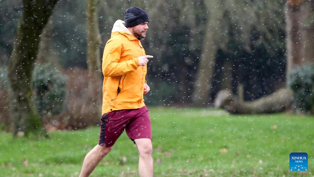 A man jogs in snow in London, Britain, on Jan. 8, 2024.(Photo: Xinhua)