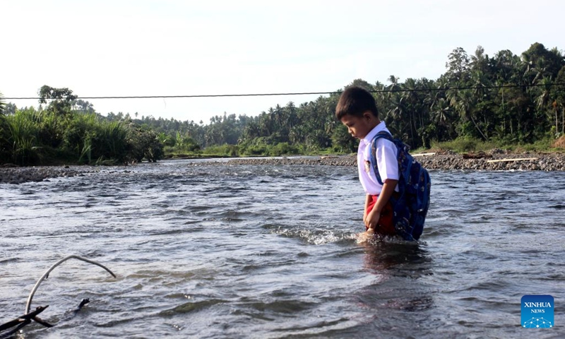 A student crosses a river on the way to school at a village in West Sumatra, Indonesia, Jan. 8, 2024.(Photo: Xinhua)