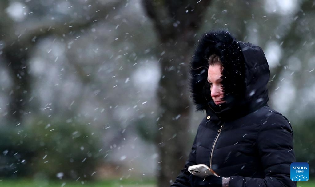 A woman walks in snow in London, Britain, on Jan. 8, 2024.(Photo: Xinhua)