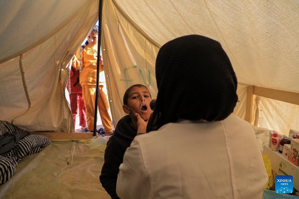 A doctor checks the condition of a boy at a temporary clinic in the southern Gaza Strip city of Rafah, on Jan. 8, 2024. Israel has been fighting with Hamas in the Gaza Strip since Oct. 7, 2023, after the Palestinian faction launched a surprise attack on southern Israel that killed about 1,200 people. The Israeli army has so far killed more than 23,000 Palestinians in its military operations in the enclave, the Gaza-based Health Ministry said Monday.(Photo: Xinhua)