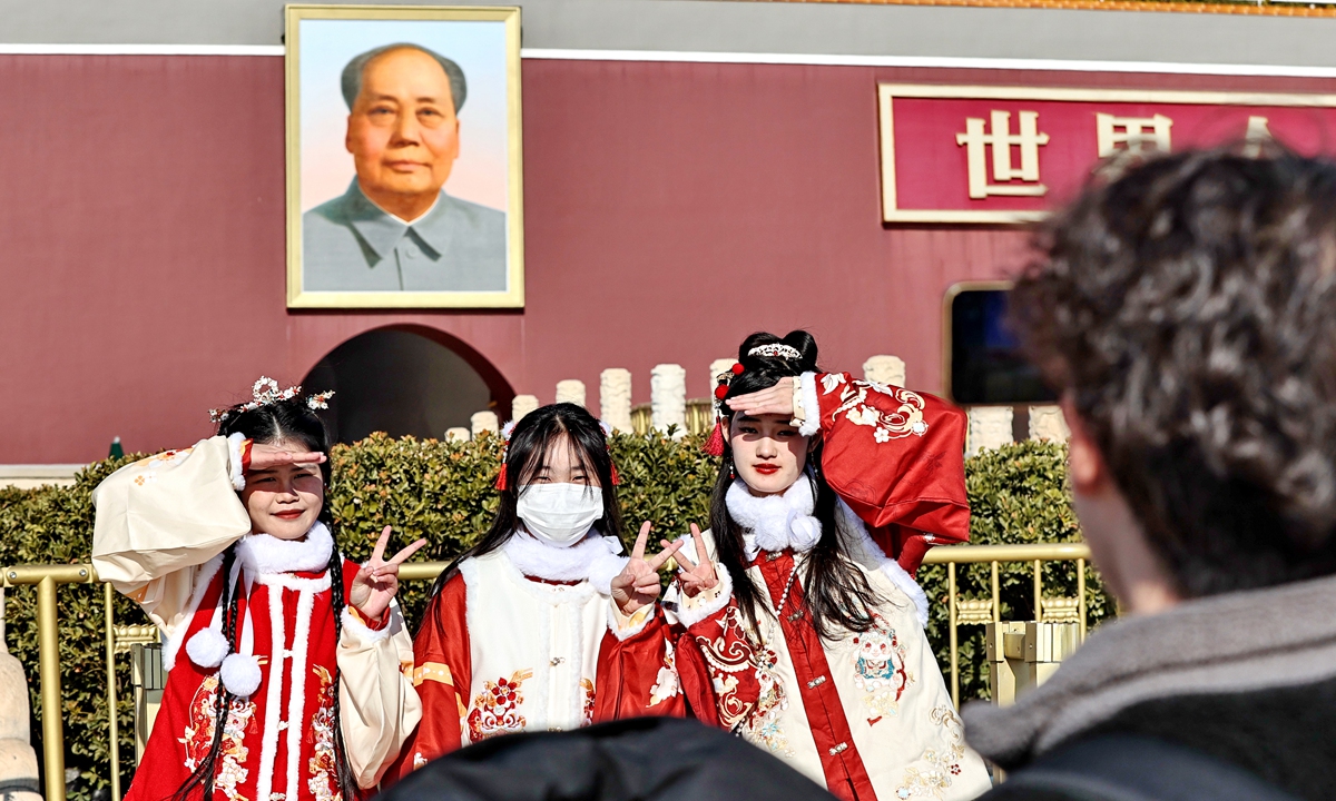 Three tourists in traditional Chinese clothing pose for a picture at Tian'anmen Square in downtown Beijing on January 10, 2024. That day, Beijing continued to warm up with a little help from the afternoon sunshine. The highest temperature climbed to 5 C, making people feel a bit of warmth in the height of the winter season. Photo: IC