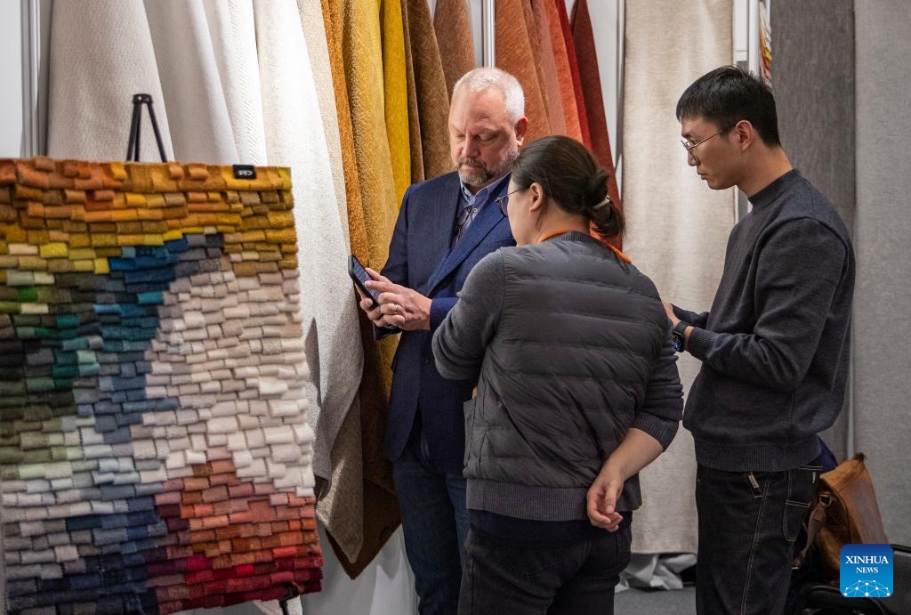 Chinese exhibitors talk with a visitor at the Heimtextil 2024 in Frankfurt, Germany, Jan. 9, 2024. Heimtextil 2024, an international platform for home and contract textiles and textile design, kicked off Tuesday in Frankfurt(Photo: Xinhua)