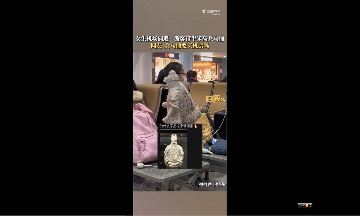 Tourist takes a half-meter-tall Terracotta Warrior figurine at airport in Xi'an. Photo: Screenshot from Bailu Video