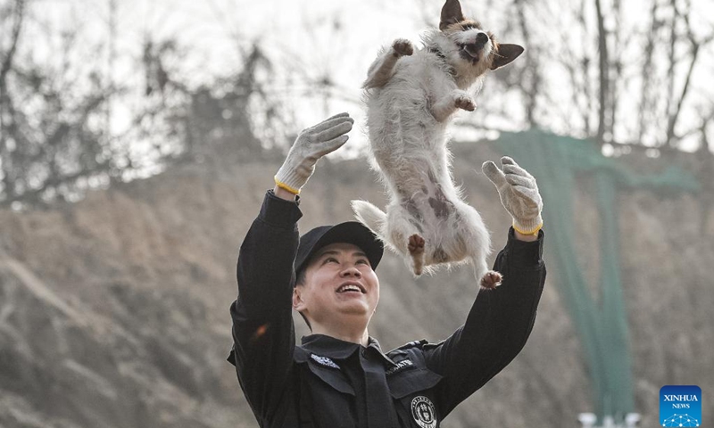 A trainer interacts with a police dog during a training session break in Huangshi, central China's Hubei Province, Jan. 10, 2024. A police dog unit of the public security bureau in Huangshi of Hubei carried out a training session on Wednesday in order to ensure the safety of the upcoming Spring Festival travel rush.(Photo: Xinhua)