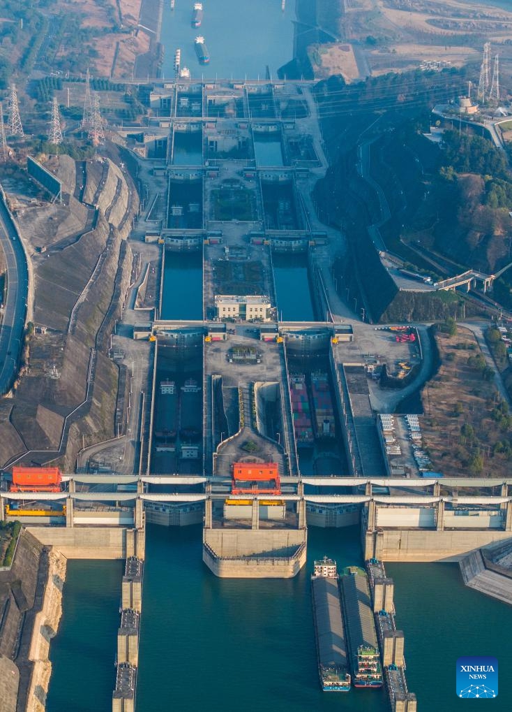 An aerial drone photo taken on Jan. 11, 2024 shows vessels passing through the five-tier ship locks of the Three Gorges Dam in Yichang, central China's Hubei Province. The cargo throughput via the Three Gorges Dam, the world's largest hydropower project on the upper stream of the Yangtze River, reached a record high of 172.34 million tonnes in 2023, up 7.95 percent year on year, according to the China Three Gorges Corporation.(Photo: Xinhua)