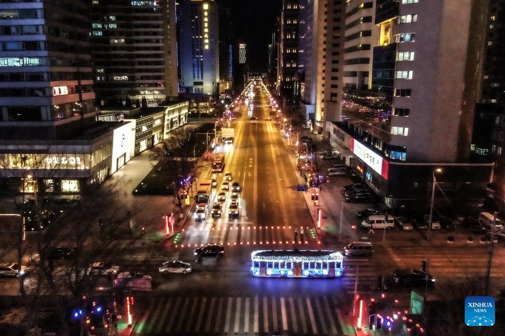 An aerial drone photo taken on Jan. 9, 2024 shows a tram moving in Dalian, northeast China's Liaoning Province. Since Dec. 31, 2023, several trams in Dalian have been decorated with lights in order to attract more tourists. The history of tram in Dalian City dates back to 1909. After more than 100 years of operation, the tram has become a popular icon of the city.(Photo: Xinhua)