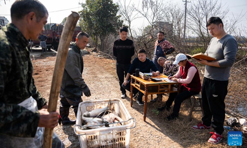 Fishermen sell fishes just caught in Yanhedi Village, Nanxian County, central China's Hunan Province, Jan. 13, 2024. Nanxian County saw busy winter fish catching by local fishermen at present to meet the demand of the market. The annual output of aquatic products in the county reached 162,000 tons in 2023. (Xinhua/Chen Sihan)