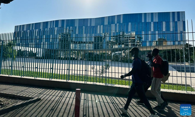 This photo taken with a mobile phone on Jan. 10, 2024 shows people walking past the presidential palace of Cote d'Ivoire in Abidjan, Cote d'Ivoire. Abidjan is the largest city and economic capital of Cote d'Ivoire. (Xinhua/Han Xu)