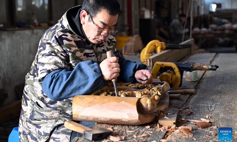 A staff member carves a decorative component for Huizhou-style antique buildings in Huangshan City, east China's Anhui Province, Jan. 11, 2024. Huangshan has boosted construction service specialized in Huizhou-style antique buildings in an innovative way, attracting many enterprises and talents to engage in the industry. Up to now, there are 254 enterprises and over 14,000 craftsmen involved, who specialize in erecting antique buildings, renovating ancient buildings and preparing materials and components for these buildings. (Xinhua/Zhou Mu)