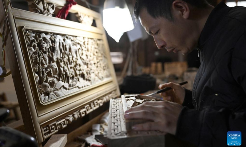 A staff member carves a decorative component for Huizhou-style antique buildings in Huangshan City, east China's Anhui Province, A staff member carves a decorative component for Huizhou-style antique buildings in Huangshan City, east China's Anhui Province, Jan. 12, 2024. (Xinhua/Zhou Mu)