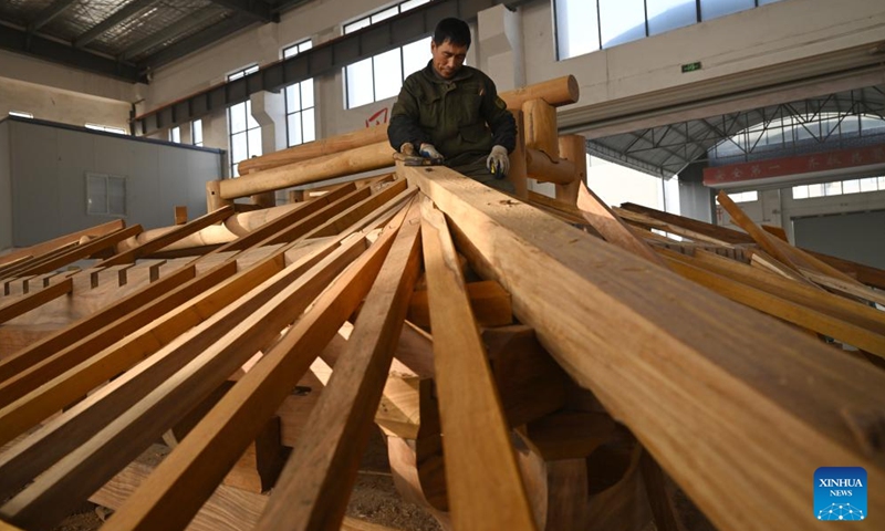 A staff member sets up a wooden structure for Huizhou-style antique buildings in Huangshan City, east China's Anhui Province, Jan. 11, 2024. (Xinhua/Zhou Mu)