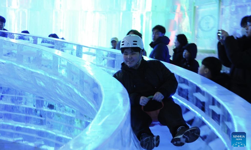 A tourist enjoy an ice slide made by Harbin ice sculptors during Hwacheon Sancheoneo Ice Festival in Gangwon Province, South Korea, Jan. 13, 2024. The capital of China's northernmost province of Heilongjiang, Harbin is renowned as the crown jewel of ice and snow in the country. This year ice sculptors from Harbin have been invited to create ice sculptures for the Hwacheon Sancheoneo Ice Festival, one of the most popular South Korean winter festivals. (Photo by Yang Chang/Xinhua)