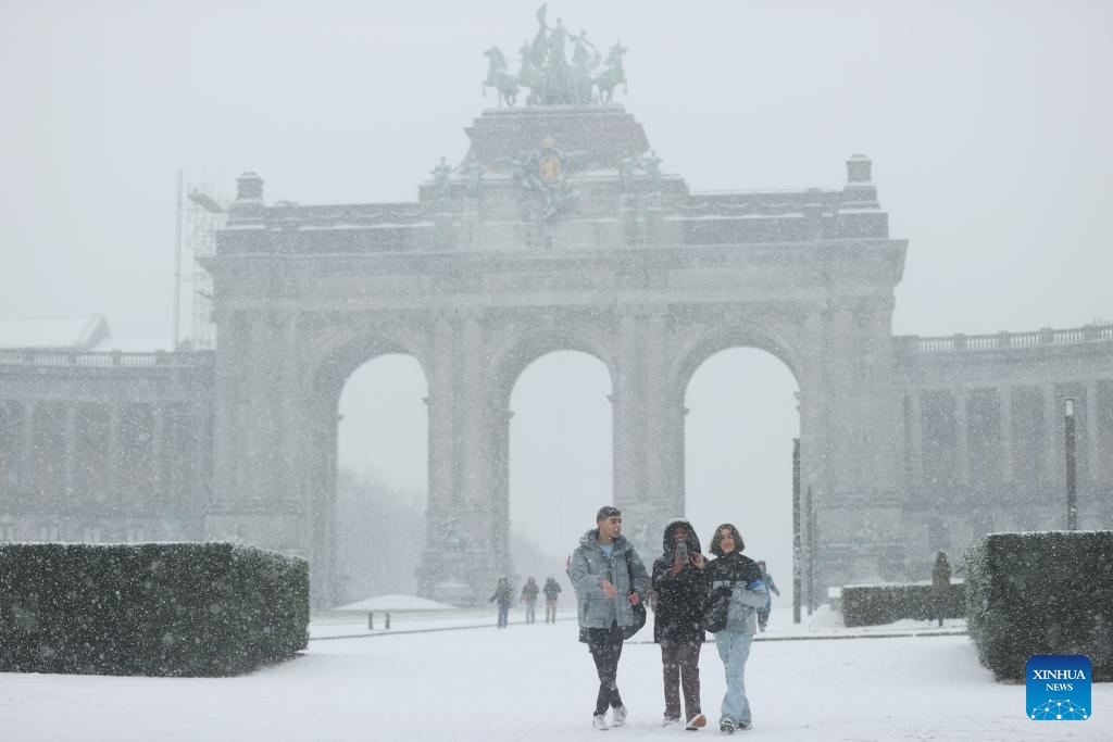 People walk in the Park of the Fiftieth Anniversary in the snow in Brussels, Belgium, Jan. 17, 2024.(Photo: Xinhua)