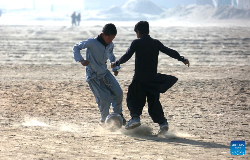 Afghan boys play football in the cold weather on a dusty ground at the Alokhil village in Kabul, capital of Afghanistan, Jan, 16, 2024.(Photo: Xinhua)