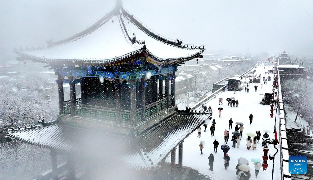 A drone photo taken on Jan. 16, 2024 shows tourists visiting the snow-covered ancient city wall in Xi'an, northwest China's Shaanxi Province.(Photo: Xinhua)