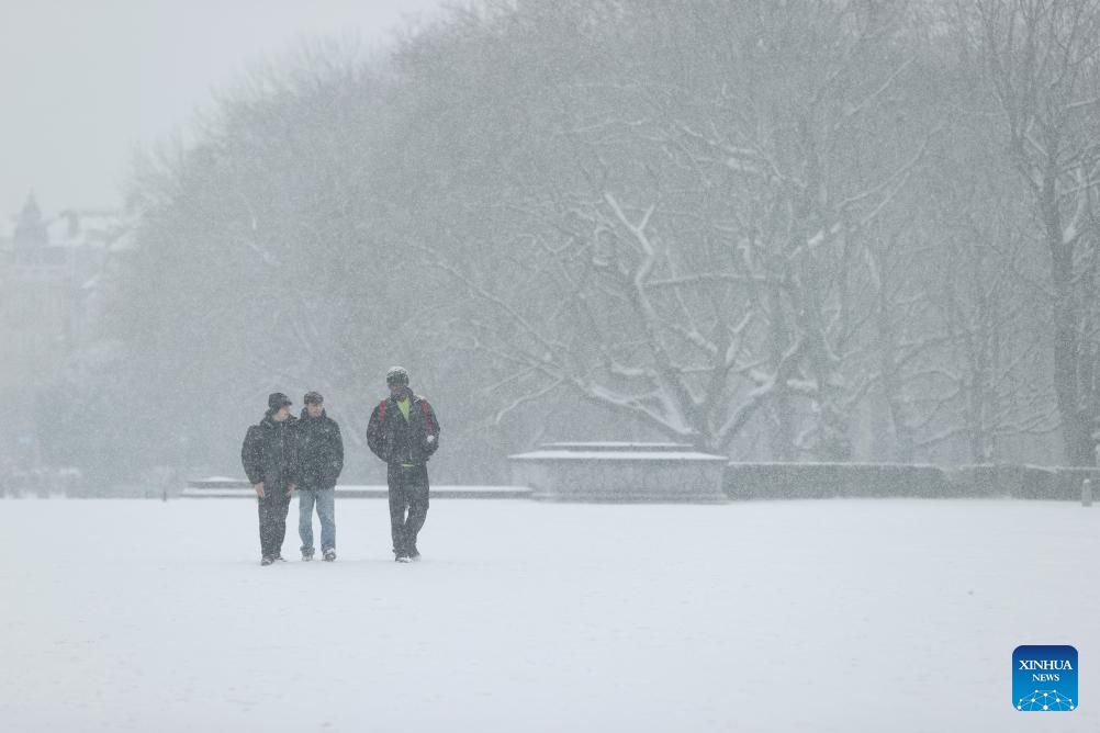 People walk in the Park of the Fiftieth Anniversary in the snow in Brussels, Belgium, Jan. 17, 2024.(Photo: Xinhua)