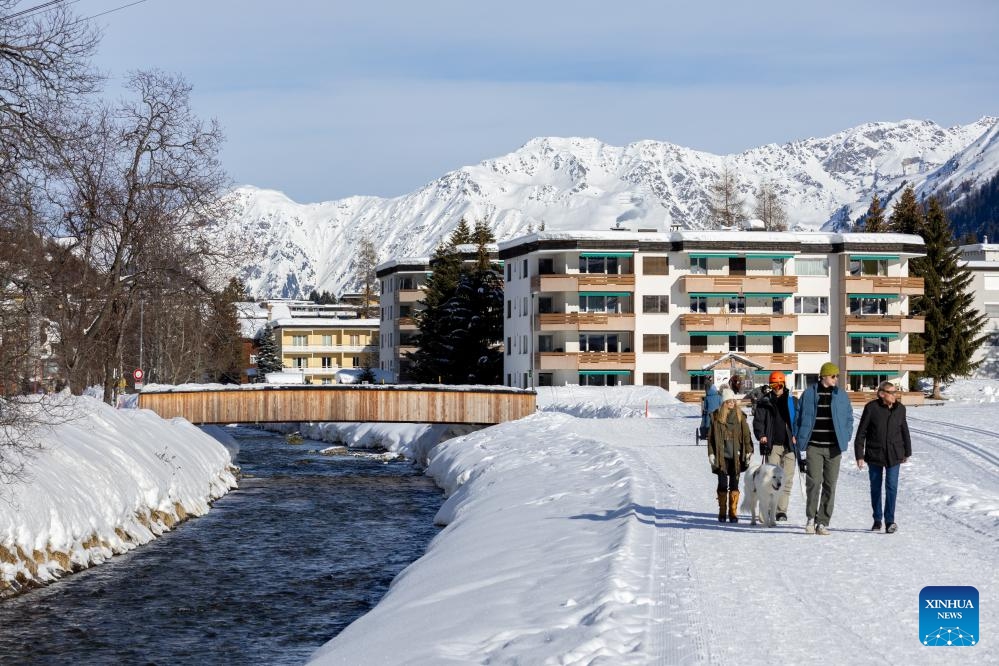 People walk past Landwasser River at Davos, Switzerland, Jan. 16, 2024.(Photo: Xinhua)