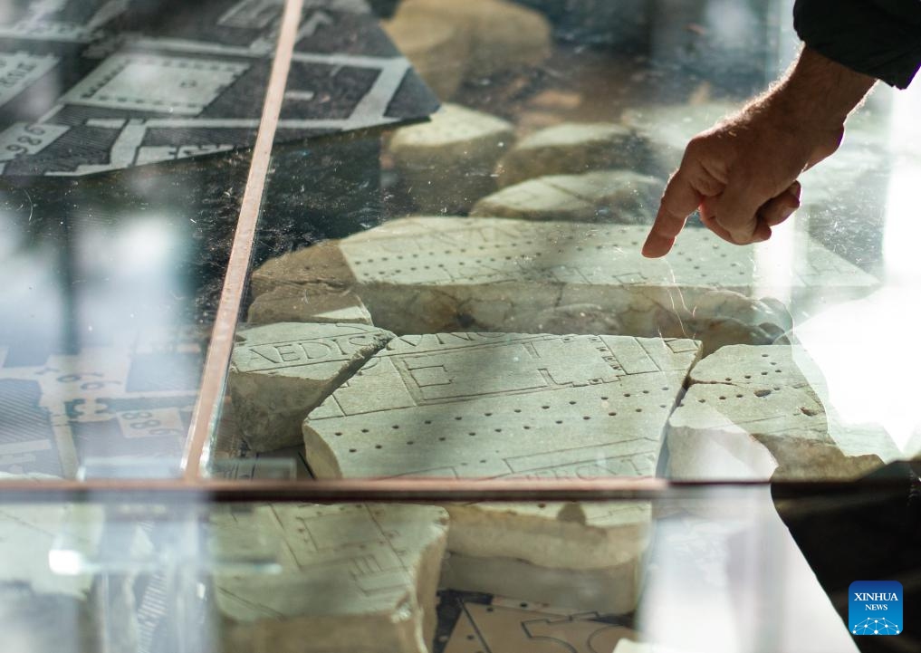 A visitor points at the fragments of the marble map of the ancient Rome in the Museum of Forma Urbis in Rome, Italy, Jan. 16, 2024. The Museum of the Forma Urbis, enclosed within a new archaeological park, opened to the public recently. The museum houses the remaining fragments of the Forma Urbis Romae, the giant marble map of ancient Rome engraved between 203 and 211 AD.(Photo: Xinhua)