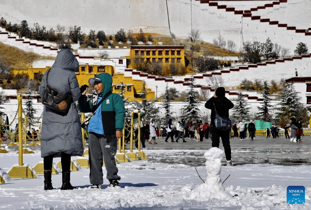 Tourists visit the Potala Palace square in Lhasa, southwest China's Xizang Autonomous Region, Jan. 18, 2024. Snow fell in Lhasa on Thursday.(Photo: Xinhua)