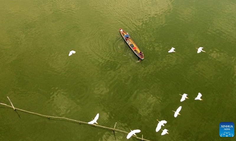 An aerial drone photo taken on Jan. 18, 2024 shows a fisherman rowing a wooden boat near floating fish farms in Lhokseumawe, Aceh Province, Indonesia.(Photo: Xinhua)