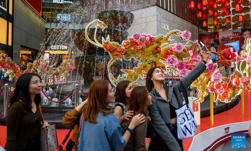 People pose for a selfie with dragon-shaped installations in celebration of the upcoming Chinese zodiac Year of the Dragon in front of a shopping mall in Kuala Lumpur, Malaysia, on Jan. 19, 2024. (Photo by Chong Voon Chung/Xinhua)