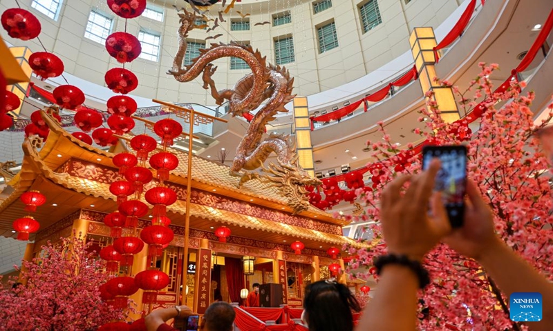 People take photos of a dragon-shaped installation in celebration of the upcoming Chinese zodiac Year of the Dragon at a shopping mall in Kuala Lumpur, Malaysia, on Jan. 18, 2024. (Photo by Chong Voon Chung/Xinhua)