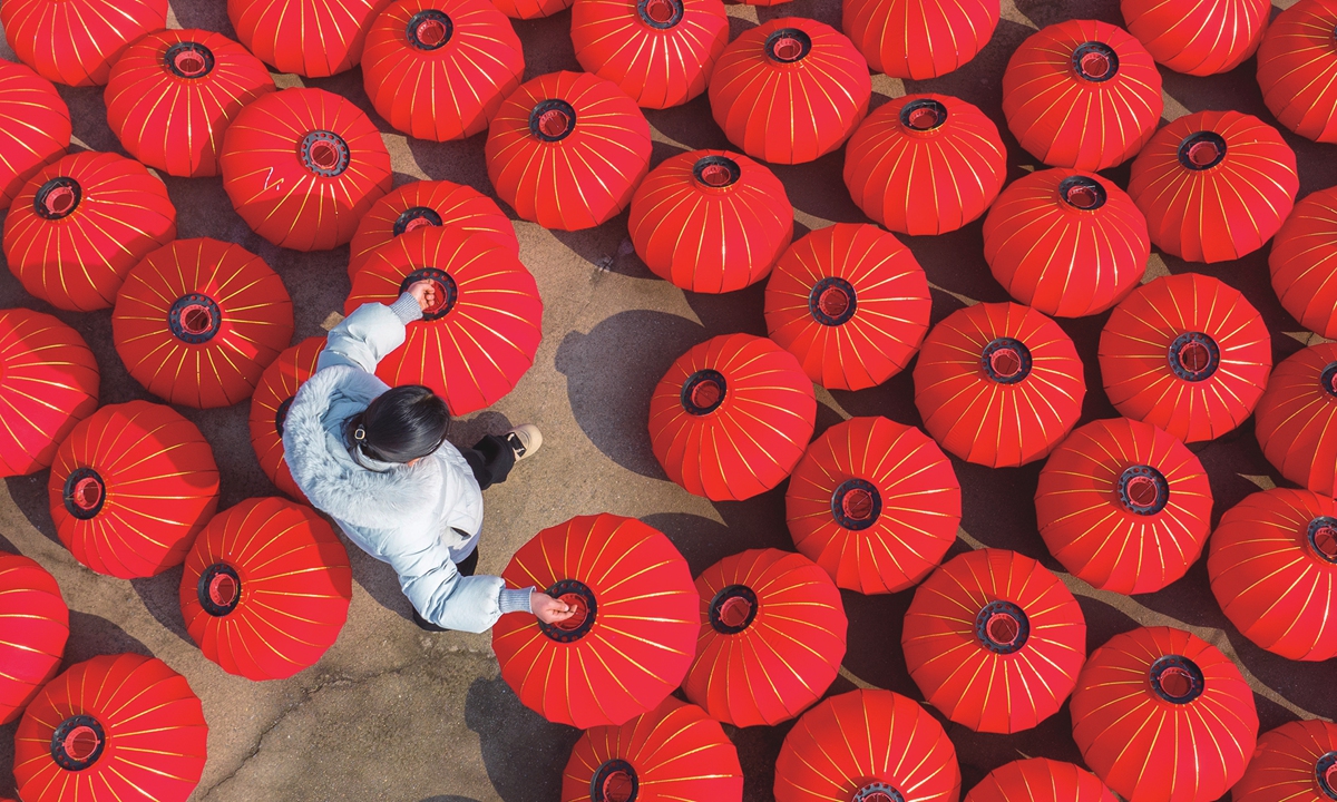 A worker from a factory in Bancheng, East China's Jiangsu Province, takes advantage of good weather to dry and make red lanterns on January 21, 2024, to ensure supply for the Spring Festival market. Photo: VCG 