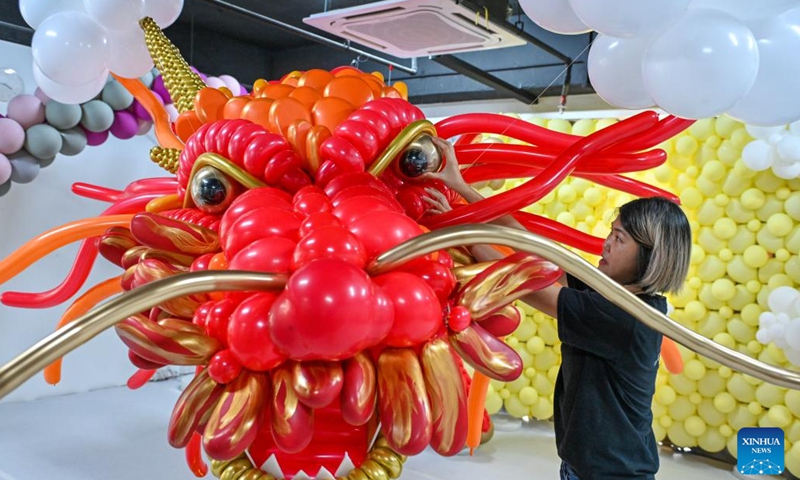 Syndy Tan uses balloons to build a dragon-shaped installation in Kuala Lumpur, Malaysia, on Jan. 18, 2024. In celebration of the upcoming Chinese zodiac Year of the Dragon, Tan, who is good at balloon creations, has used over 600 balloons to build the vivid dragon. (Photo by Chong Voon Chung/Xinhua)