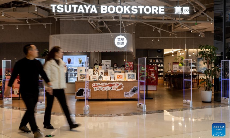 People pass by Tsutaya Bookstore in Yuzhong District of southwest China's Chongqing Municipality, Jan. 21, 2024. (Xinhua/Chu Jiayin)