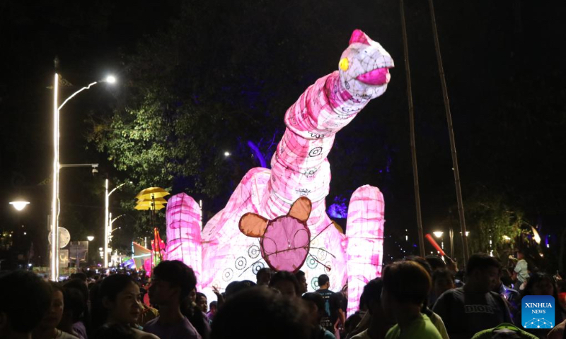 A giant dinosaur puppet parades along a street in Siem Reap, Cambodia, Feb. 24, 2024. An annual giant puppet parade was held here on Saturday. (Photo by Sao Khuth/Xinhua)