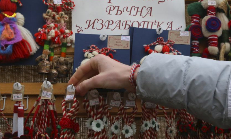 A stall owner arranges Martenitsi for sales in Sofia, Bulgaria, March 1, 2024. Bulgarian people marked the day named Baba Marta on Friday. On that day and a few days afterwards, Bulgarians exchange and wear the so-called Martenitsa - a small piece of adornment, made of white and red yarn. (Xinhua/Lin Hao)