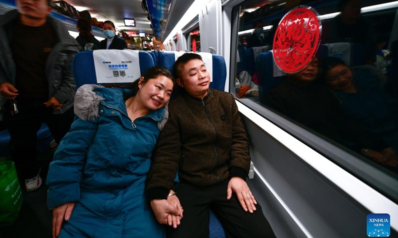 Min Deshui and Long Chunxiang take the train G4835 on Feb. 1, 2024.