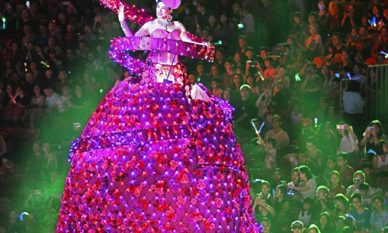 A performer waves to spectators during the Chingay Parade as part of the Lunar New Year celebrations in Singapore's F1 Pit Building on Feb. 23, 2024. (Photo by Then Chih Wey/Xinhua)