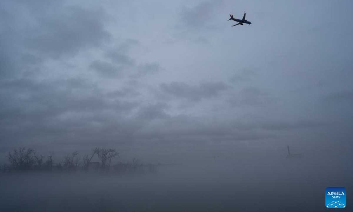 This photo taken on Jan 25, 2024 from Arlington, Virginia shows an airplane flying over the Washington Monument shrouded in fog in Washington, DC, the United States. Photo:Xinhua