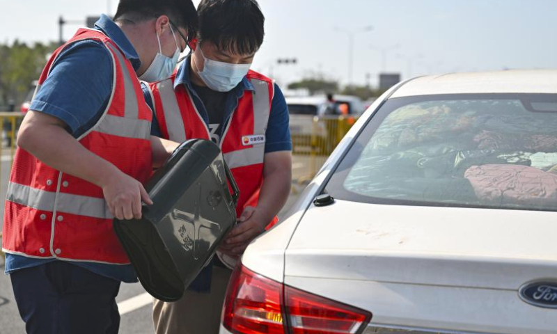 Staff members from China National Petroleum Corporation (CNPC) refuel a car waiting to cross the strait in Haikou, south China's Hainan Province, Feb. 17, 2024. Qiongzhou Strait witnessed a peak of travel rush of returning passengers on Feb. 17, the last day of the Spring Festival holiday.

Various actions were taken by local authorities to ensure passengers to cross the strait in an orderly manner including organizing personnel to maintain the queuing order, providing emergency medicines, drinking water and other supplies to drivers and tourists. (Xinhua/Guo Cheng)