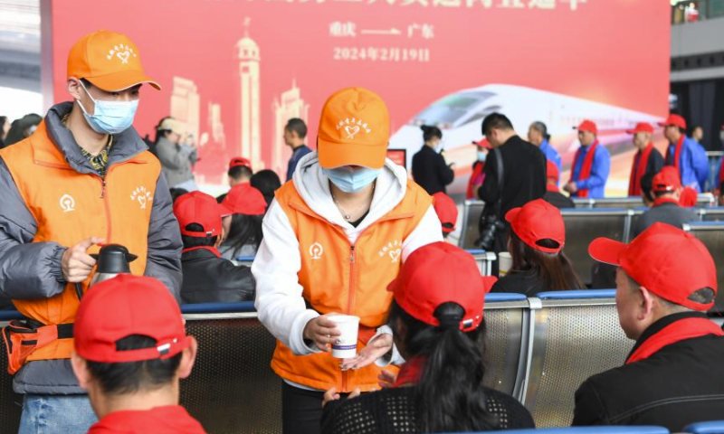 Volunteers serve hot water for migrant workers at Chongqing West Railway Station in southwest China's Chongqing Municipality, Feb. 19, 2024. Train G3729, a chartered train for migrant workers who are about to return to work, left Chongqing West Railway Station here on Monday and headed towards Guangzhou South Railway Station. It is the first train of its kind that departed from Chongqing after the Spring Festival holiday this year. Over 300 migrant workers from Chongqing and southwest China's Sichuan Province took the train. (Xinhua/Wang Quanchao)