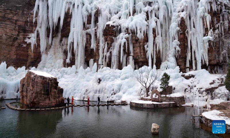 Tourists enjoy the frozen waterfall scenery at the Tianhe Mountain scenic spot in Xingtai, north China's Hebei Province, Feb. 14, 2024. More Chinese people nowadays choose to go on a journey during the Spring Festival to experience different cultures and lunar new year atmosphere. (Photo by Chen Lei/Xinhua)