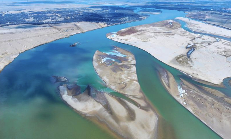 An aerial drone photo taken on March 1, 2024 shows the scenery at a section of the Yellow River in northwest China's Ningxia Hui Autonomous Region. With the temperature rising, the ice in Ningxia section of the Yellow River has been gradually melting. Flocks of migratory birds fly over the tidal-flat area and the turquoise water, adding a touch of vitality to the spring scenery. (Xinhua/Wang Peng)

