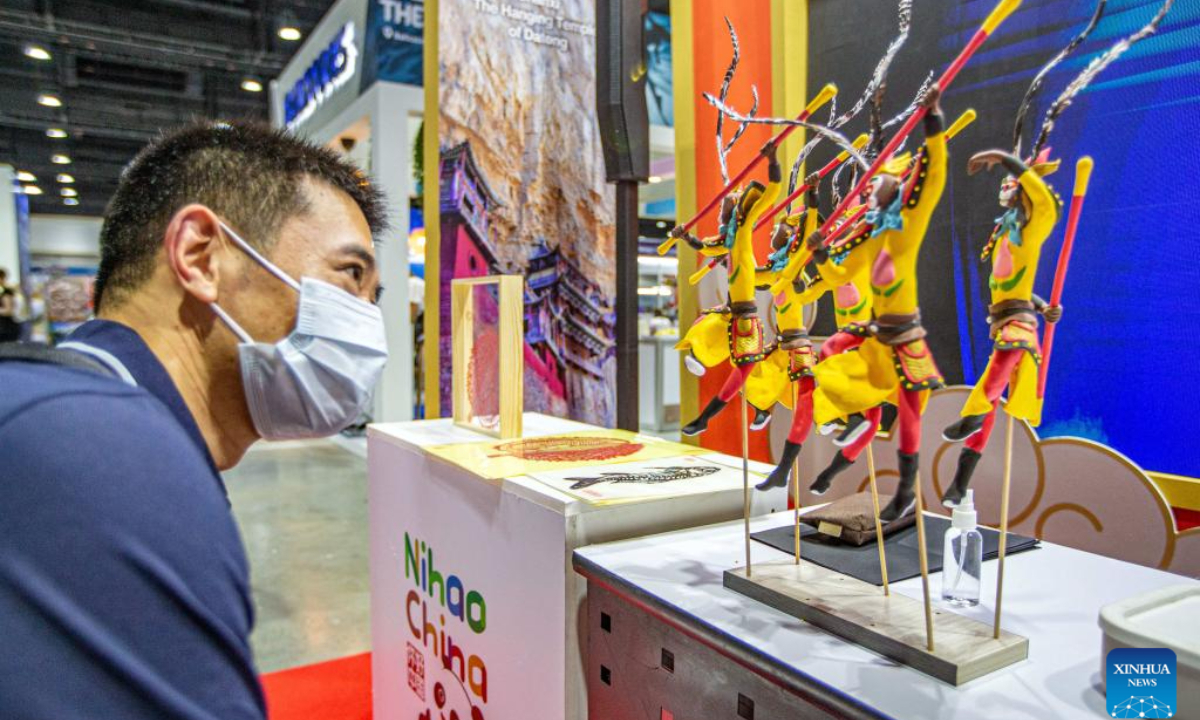A visitor watches exhibits at a booth of China during the 29th Thailand International Travel Fair in Bangkok, Thailand, Jan 25, 2024. The fair kicked off here on Thursday and will last until Jan 28. Photo:Xinhua